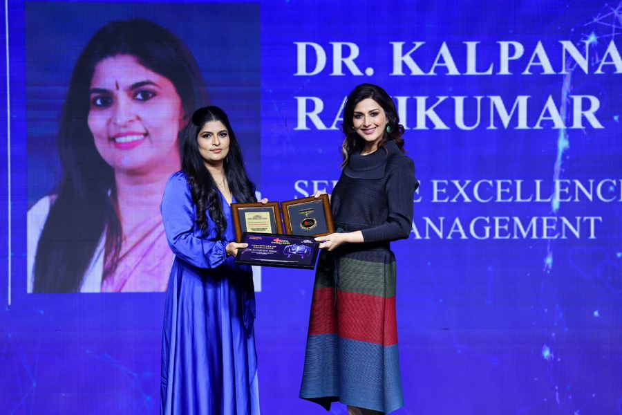 Dr. Kalpana Ravikumar receiving the Times Health Excellence award on stage